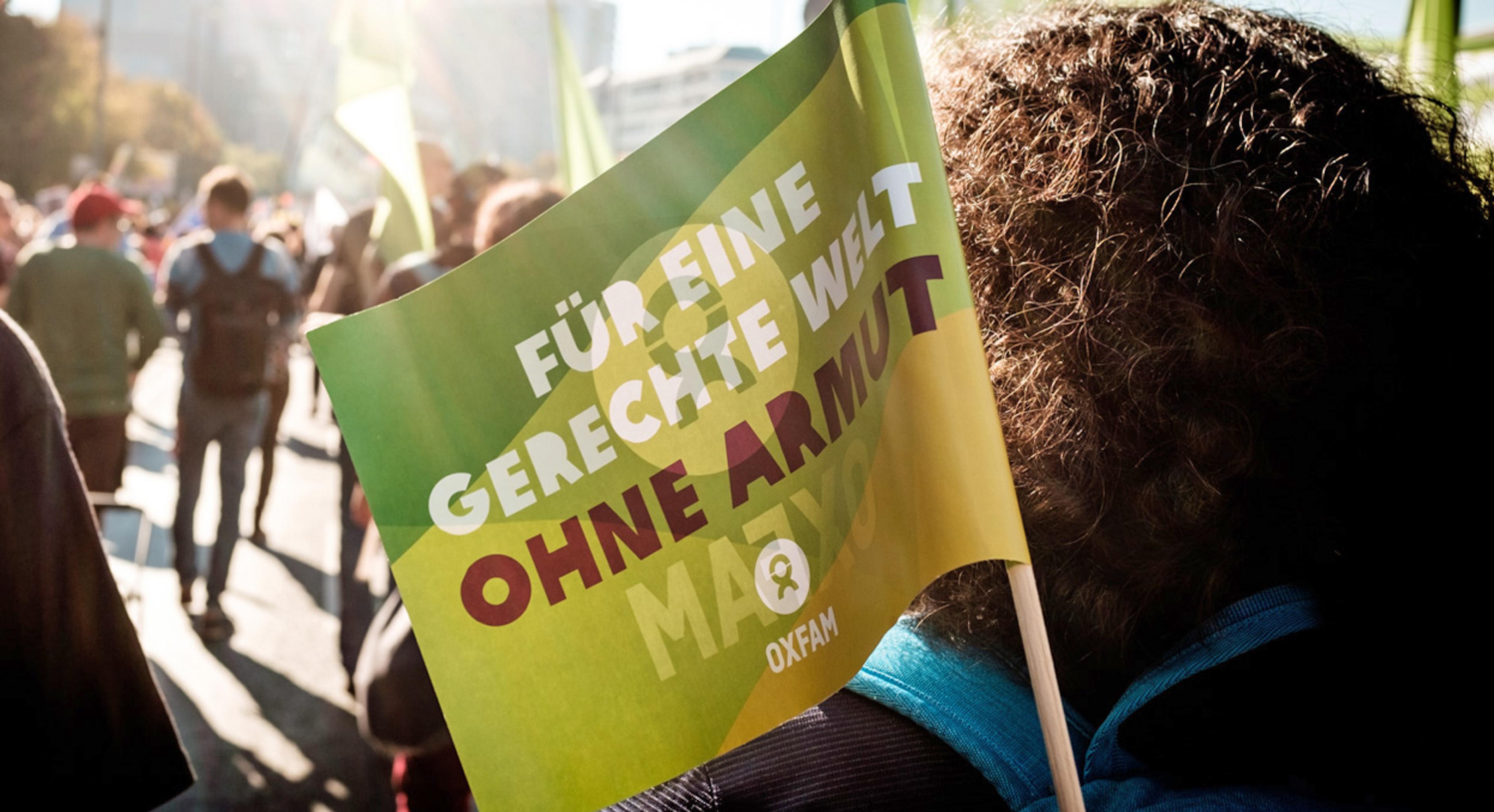 Eine Oxfam-Fahne ist auf einer Demonstration zu sehen