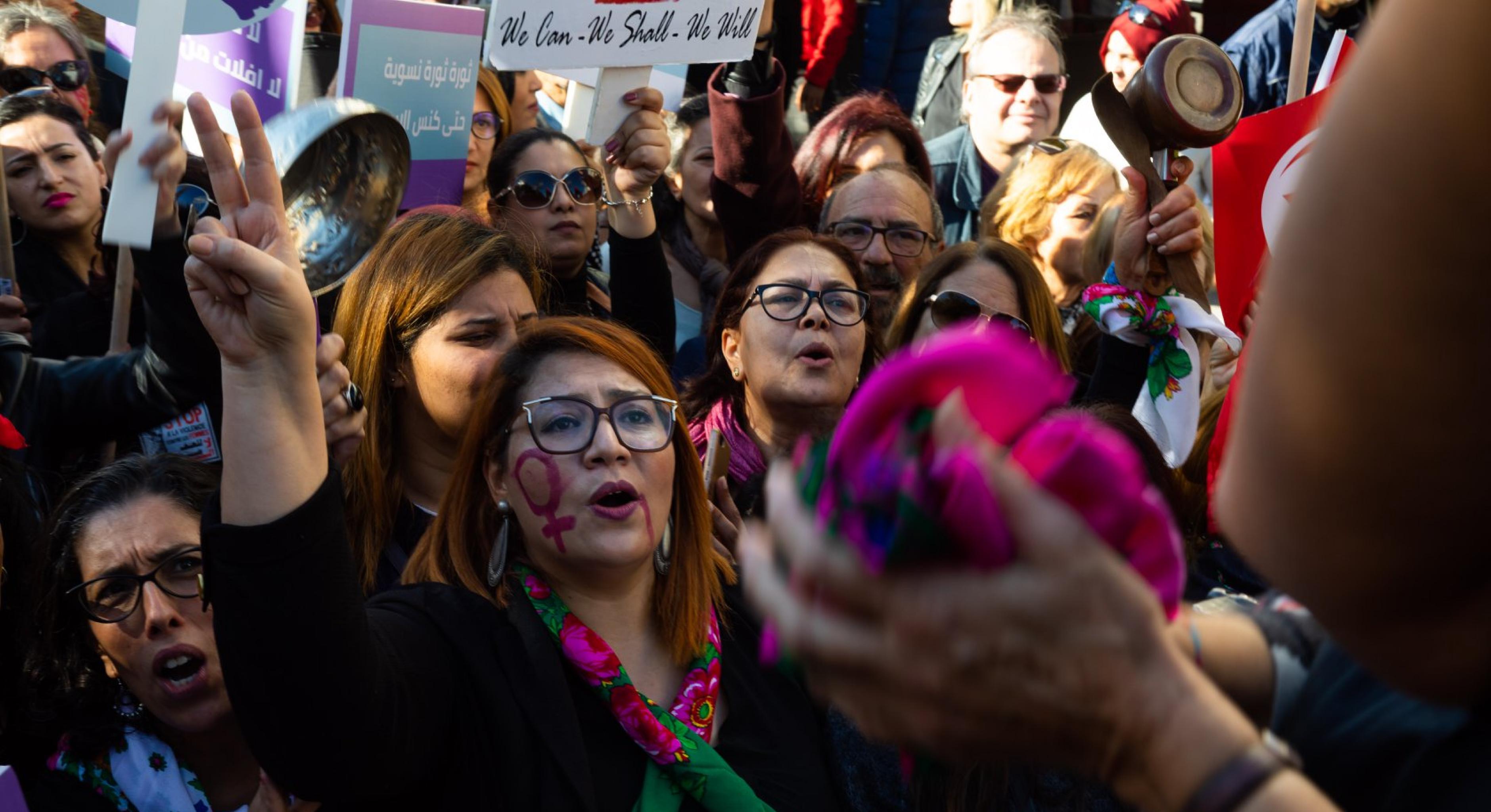 Frauen und Männer demonstrieren demonstrieren mit Bannern, Halstüchern und Pfannen