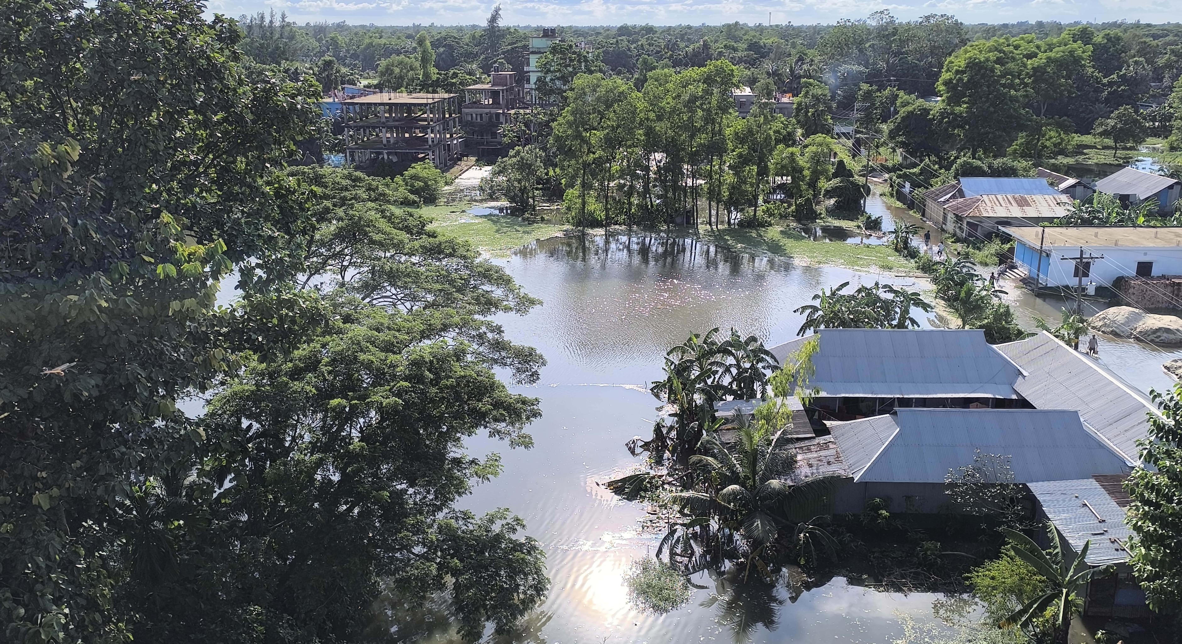 Eine von der Flutkatastrophe betroffene Gemeinde in Bangladesch kämpft mit den steigenden Wassermassen, die Häuser, Straßen und Ackerland überschwemmen.