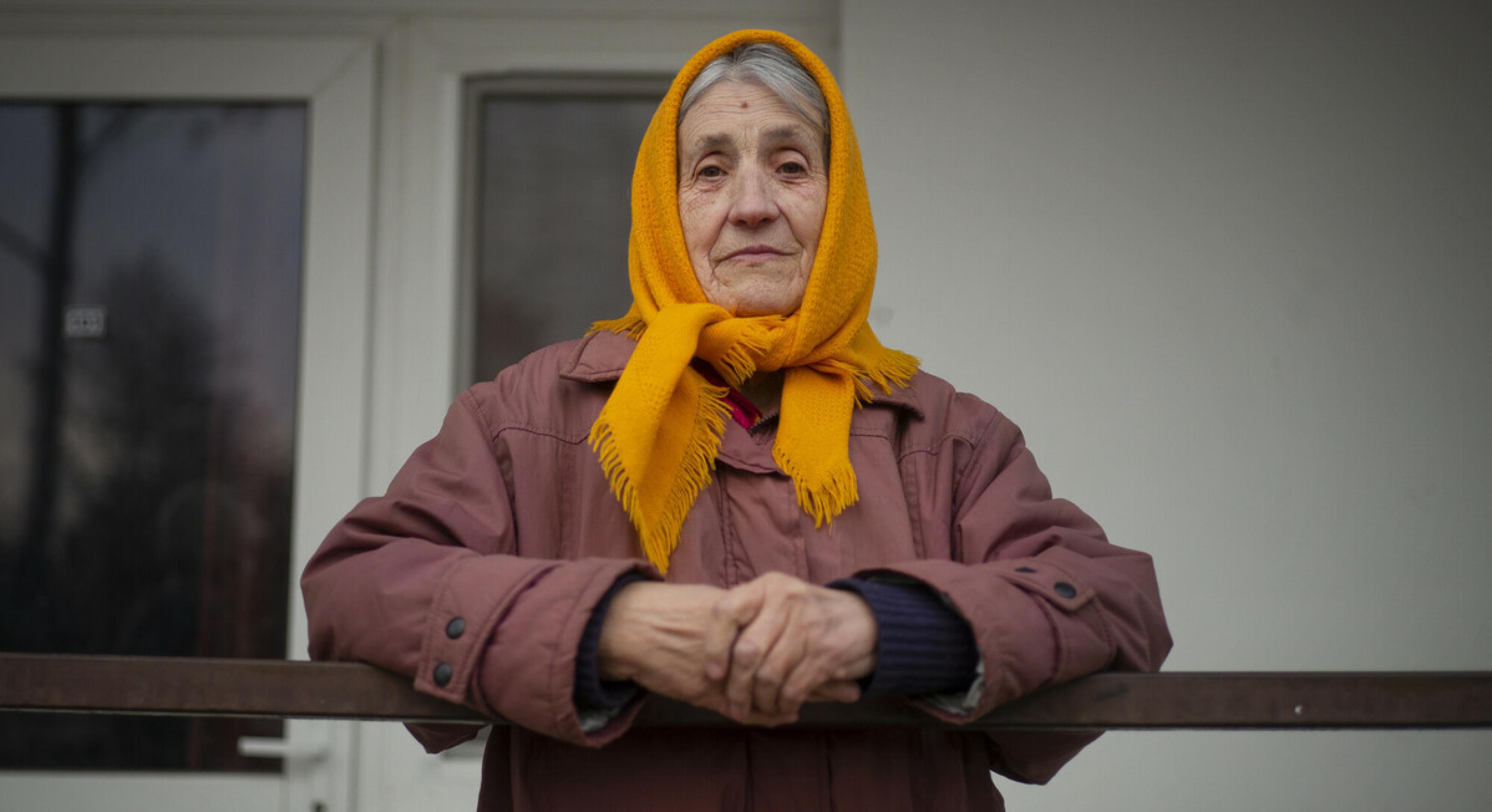 Tamara Dmytrivna steht auf einem Balkon. Sie schaut ernst in die Kamera.