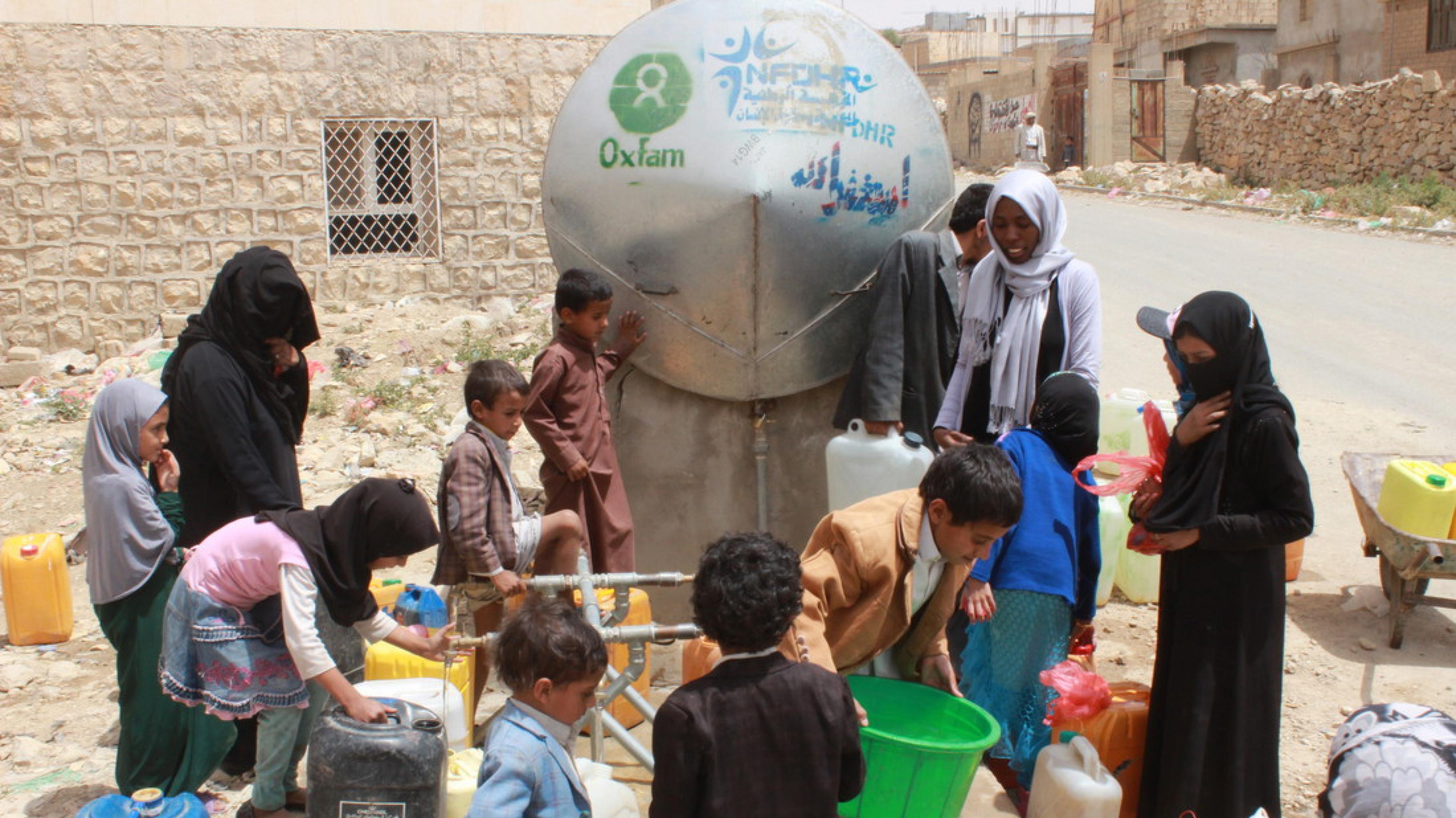 Frauen und Kinder holen Wasser an einem Tank in Khamir im Jemen.