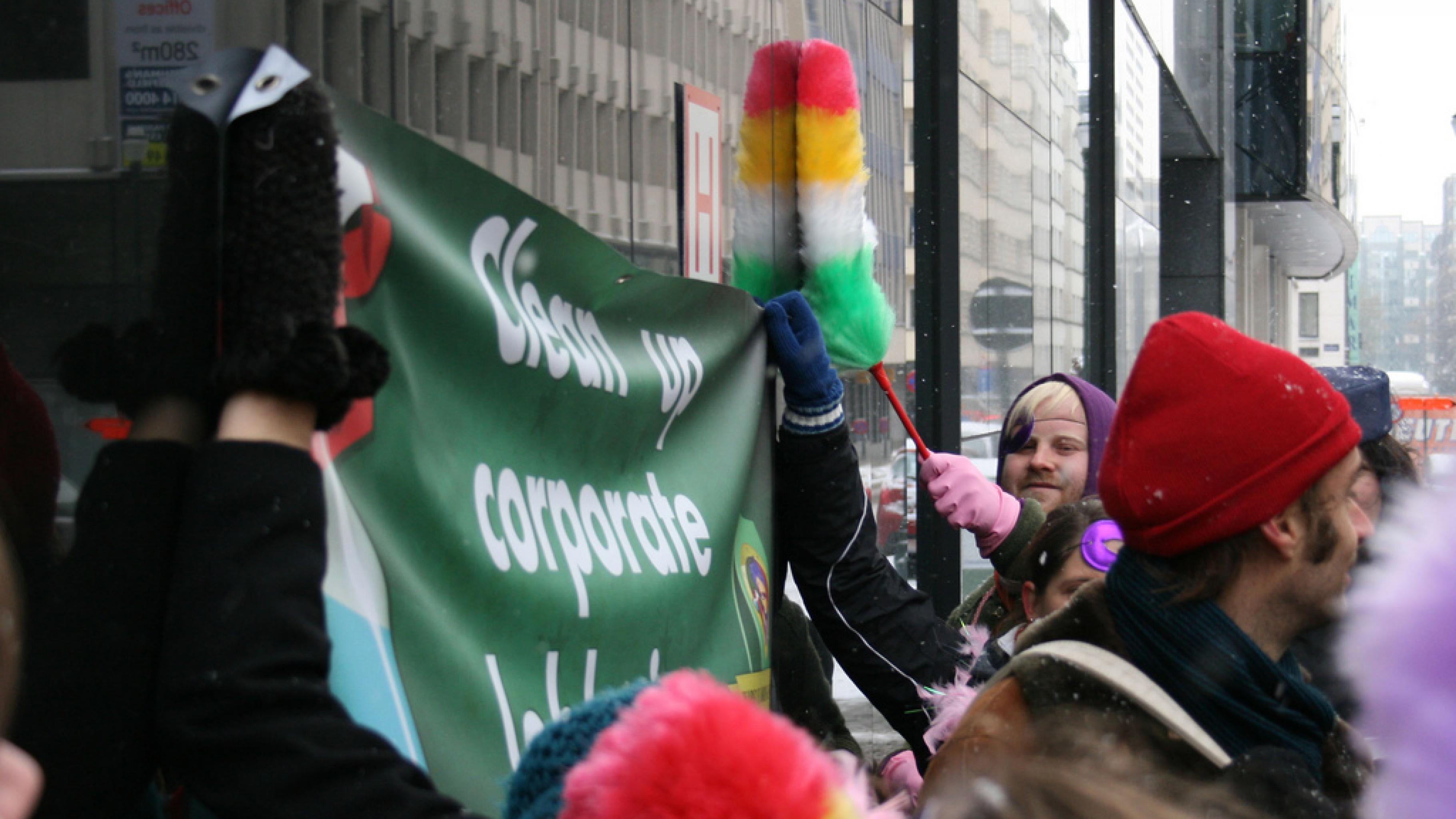 Aktivist/innen mit Banner: Clean up corporate lobbying