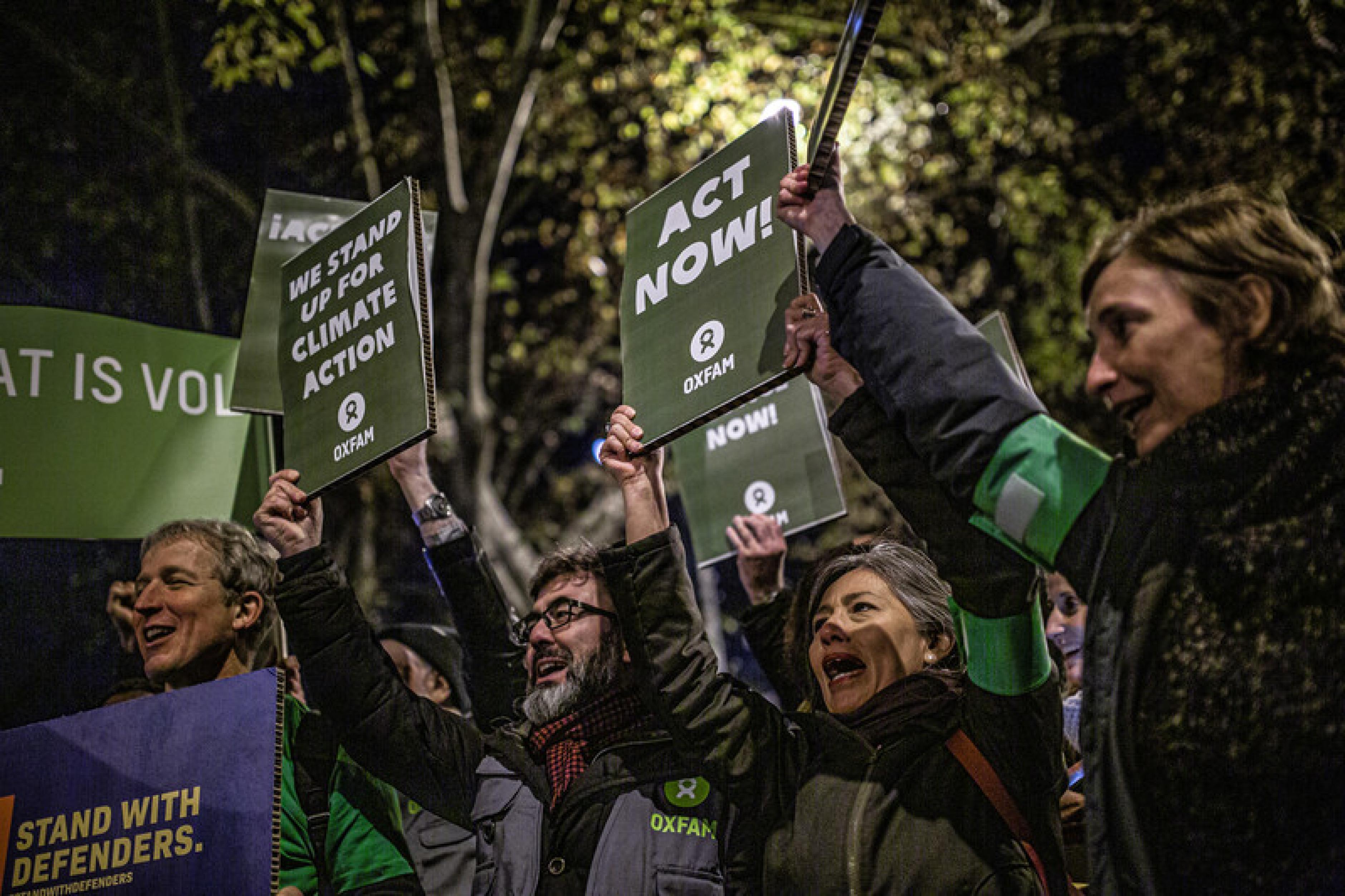 Menschen auf dem Klimaprotest in Madrid halten Schilder hoch, auf denen sie fordern jetzt zu handeln