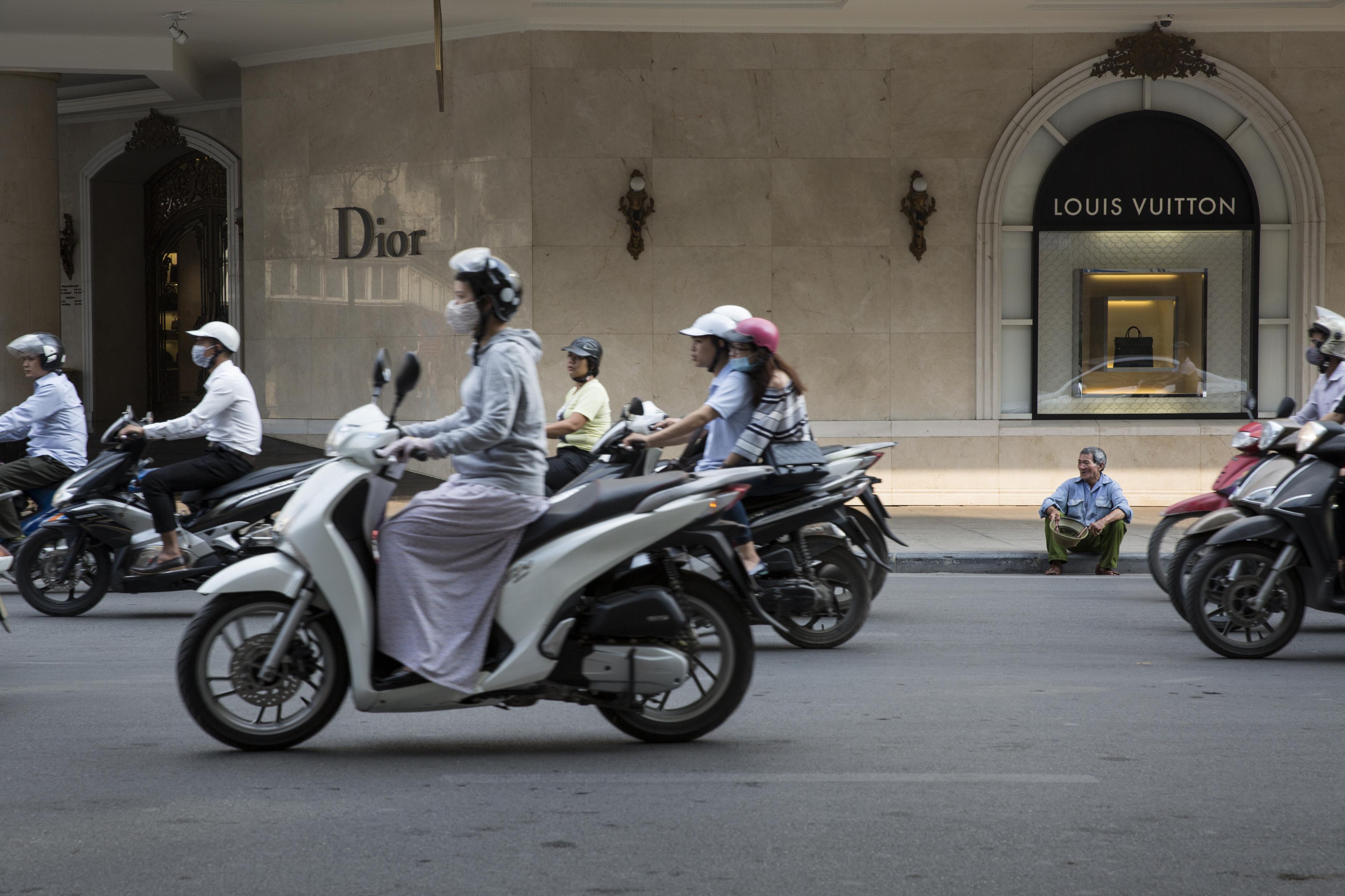 Bettelnder Mann vor einem Luxus-Designer-Geschäft