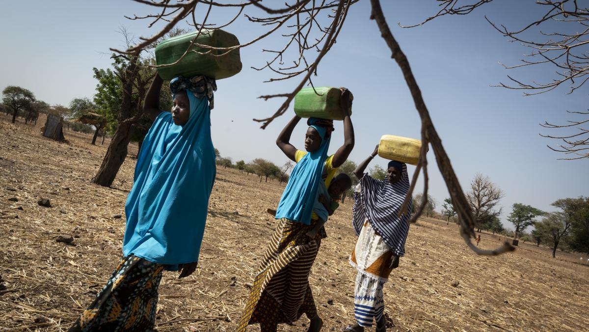 Drei Frauen tragen Wasserbehälter