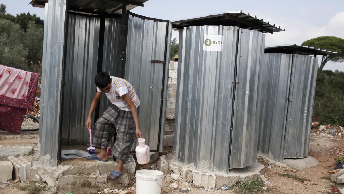Ein Jugendlicher putzt eine Latrine