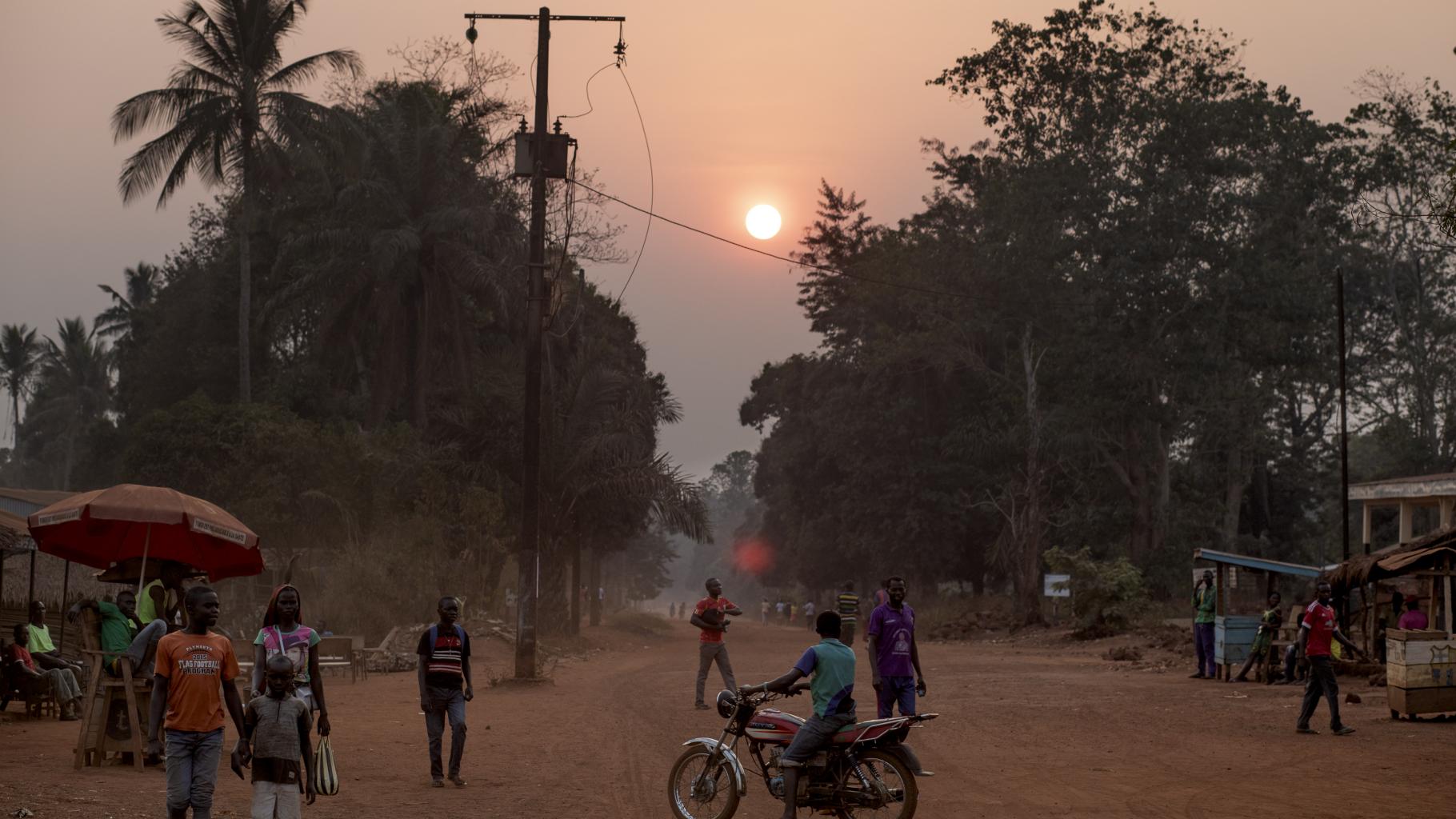 Eine Straßenszene in Bangassou, mit untergehender Sonne im Hintergrund 