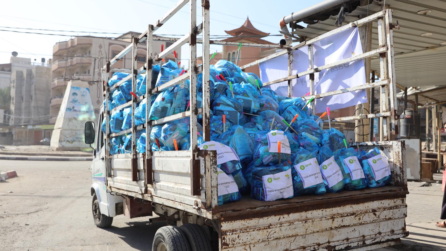Ein rostiger Lastwagen transportiert mit Hilfsgütern gefüllte blaue Plastiksäcke