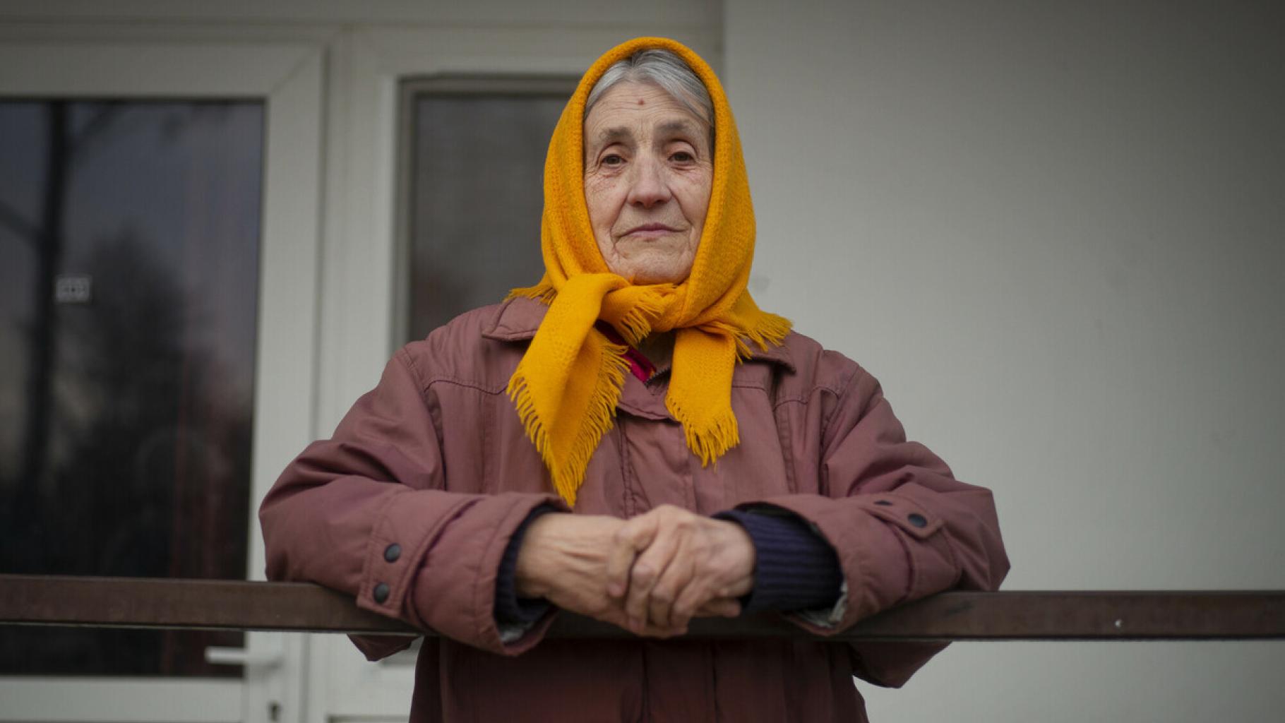 Tamara Dmytrivna steht auf einem Balkon. Sie schaut ernst in die Kamera.