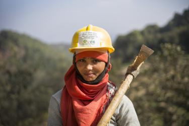 Eine Frau in Nepal mit einer Spitzhacke