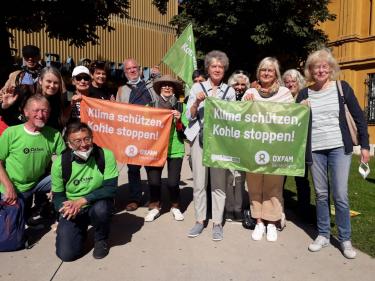 Klima schützen, Kohle stoppen: Freiwillige der Münchener Oxfam Shops beim Klimastreik am 24.09.2021 in München. 14 Personen, Freiwillige der Münchener Oxfam Shops, halten beim Klimastreik am 24.09.2021 in München Fahnen mit der Aufschrift „Klima schützen, Kohle stoppen!“