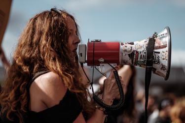 Eine Frau nutzt ein Megaphon auf einer Demo