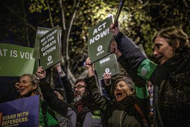 Menschen auf dem Klimaprotest in Madrid halten Schilder hoch, auf denen sie fordern jetzt zu handeln
