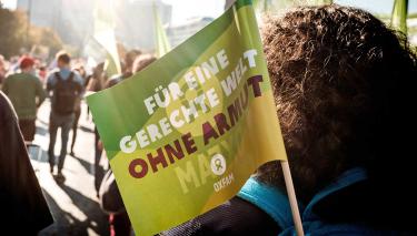 Oxfam auf der #unteilbar-Demonstration Eine Oxfam-Fahne ist auf einer Demonstration zu sehen
