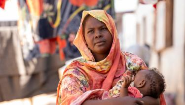 Eine Frau mit einem Baby auf dem Arm.