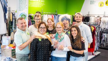 8 Ehrenamtliche auf einem Gruppenfoto im Oxfam Shop in Halle/Saale.