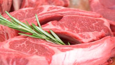 Frischfleisch spielt gerade in der Handzettelwerbung des Lebensmitteleinzelhandels eine wichtige Rolle, um mit Niedrigpreisen Verbraucher*innen in seine Märkte zu holen. Ein Preiswerbeverbot könnte den Anreiz für solche Billigpreise verringern. So könnten sich die Einnahmen erhöhen und entlang der Lieferkette zur Verbesserung der Tierhaltung und des Umweltschutzes, des Gesundheitsschutzes und der Lebenshaltung der landwirtschaftlichen Bevölkerung beitragen. Rohe Fleischstücke, dekoriert mit einem Rosmarinzweig