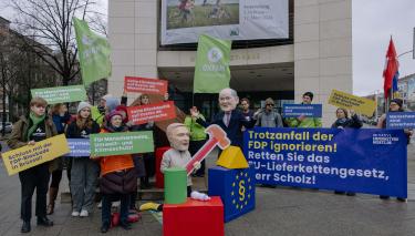 Vor dem Willy-Brandt-Haus stellen als Christian Lindner und Olaf Scholz verkleidete Aktivist*innen einen FDP-Trotzanfall dar und fordern vom Kanzler: "Trotzanfall der FDP ignorieren! Retten Sie das EU-Lieferkettengesetz, Herr Scholz!"