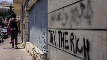 An einer Hauswand in der Innenstadt von Beirut, Libanon, steht das Graffiti „Tax the Rich“ („Besteuert die Reichen“) geschrieben.