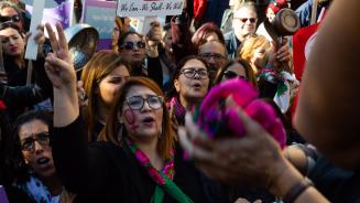 Frauen und Männer demonstrieren demonstrieren mit Bannern, Halstüchern und Pfannen