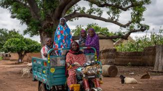 Fünf Frauen der Tungteiya-Frauenvereinigung auf ihrem neuen Motorrad mit großer Ladefläche. 