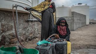 Zwei Frauen befüllen Wasserkanister 