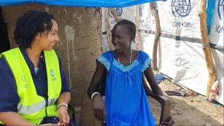 Die Direktorin von Oxfam in Afrika, Fati N'zi-Hassane (links, trägt ein dunkelblaues Hemd und eine neongelbe Weste) und Nyaguka Jiek (rechts, trägt ein blaues Kleid) sitzen auf weißen Plastikstühlen nebeneinander und unterhalten sich. 