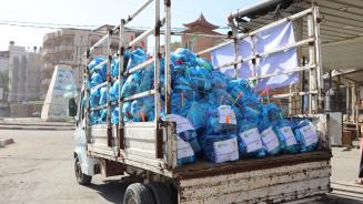 Ein rostiger Lastwagen transportiert mit Hilfsgütern gefüllte blaue Plastiksäcke