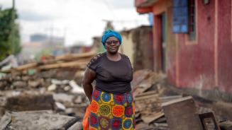 Eine Frau steht auf den Trümmern von ihrem zerstörten Haus in Mukuru Kayaba (Kenia).