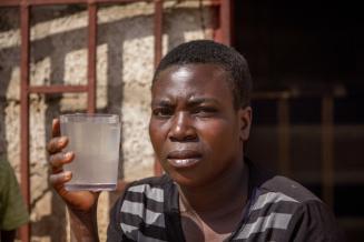 „Ich mache mir Sorgen um die Sicherheit meiner Kinder, wenn sie dieses Wasser trinken. Ich frage mich, ob es sicher ist“, sagt Priscilla Katari aus Chazanga in Sambia und zeigt Wasser aus einem selbstgebauten Brunnen. Priscilla Katari aus Chazanga in Zambia und zeigt in einem Glas verunreinigtes Wasser aus einem selbstgebauten Brunnen.