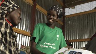 Oxfam-Mitarbeiterin in Renk im Gespräch mit Achol Ring, eine durch den Konflikt im Sudan Vertriebene, über die Bedeutung von sanitären Einrichtungen zur Verhinderung von Krankheiten