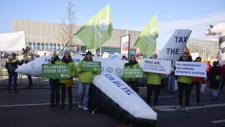 Vor einem CDU-Parteitag halten Oxfam-Aktivist*innen vor einem aufblasbaren Privatjet mit der Aufschrift „Tax the rich“ Schilder mit den Slogans „Milliardärssteuer jetzt!“, „Merz Air: Steuerfrei für Milliardär*innen“ und „Milliardärsmacht beschränken, Demokratie schützen“