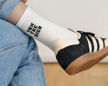 Eine Tennissocke mit der Aufschrift „Tax the Rich“ (Reiche besteuern) an einem Fuß.