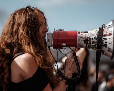 Eine Frau nutzt ein Megaphon auf einer Demo