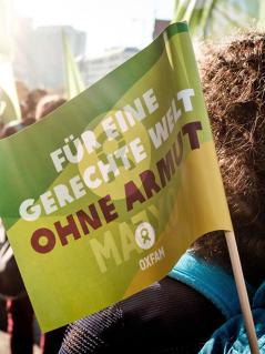 Eine Oxfam-Fahne ist auf einer Demonstration zu sehen