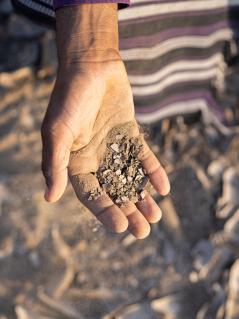 Bakeel Saif Jahes zeigt verdorrte Erde von seiner Farm in Al-Wahat in der Provinz Lahj im Jemen. Seine Arbeit wurde schon lange durch Dürre erschwert. Doch dann haben schwere Überschwemmungen seine Felder, seine Vorräte und seine gesamte Farm zerstört. Wetterextreme wie diese werden durch den Klimawandel wahrscheinlicher. Bakeel Saif Jahes hält eine Handvoll trockene, staubige Erde in die Kamera.