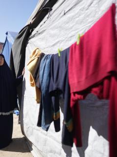 „Ich habe meine Privatsphäre verloren“, sagt Rania (Name zum Schutz der Person gekürzt) und deutet auf die Drohne am Himmel. Rania hat zwei Studienabschlüsse und lebt mit ihren fünf Kindern in einem Camp für Geflüchtete in Gaza. Eine Frau steht neben einem Zelt, an dem eine Wäscheleine mit Kleidung hängt. Sie schaut ernst in die Kamera.