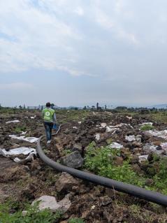 Zerwühlter Boden, Müll und dazwischen eine Wasserleitung, die eigentlich unter der Erde verlaufen sollte. Das Geflüchtetencamp in Rusayo ist verwüstet.