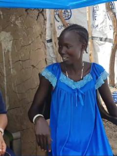 Die Direktorin von Oxfam in Afrika, Fati N'zi-Hassane (links, trägt ein dunkelblaues Hemd und eine neongelbe Weste) und Nyaguka Jiek (rechts, trägt ein blaues Kleid) sitzen auf weißen Plastikstühlen nebeneinander und unterhalten sich. 