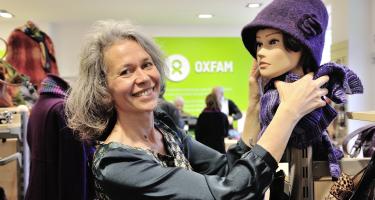 Foto: Ehrenamtliche präsentiert gespendeten Waren in einem Oxfam-Shop.
