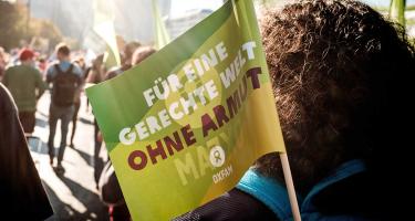 Oxfam auf der #unteilbar-Demonstration Eine Oxfam-Fahne ist auf einer Demonstration zu sehen