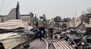 Oxfam-Mitarbeiter*innen inmitten der Verwüstung in Mandalay nach dem schweren Erdbeben vom 28. März 2025. Zwei Personen in Oxfam-Westen stehen zwischen Trümmern.