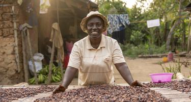 Eine Frau zeigt Kakaobohnen