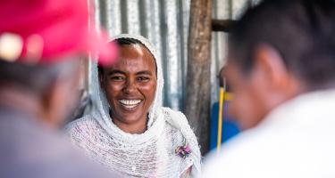 Eine Frau empfängt Kund*innen in ihrem Laden