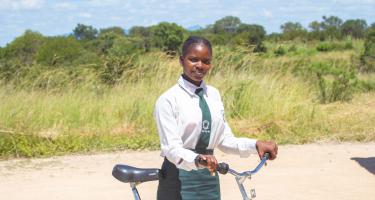 Eine junge Frau in Schuluniform mit einem Fahrrad