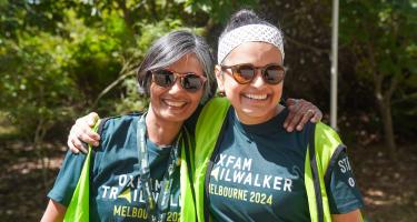 Zwei Frauen schauen lächelnd in die Kamera. Auf ihren Shirts steht: Oxfam Trailwalker Melbourne 2024.