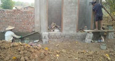 Bau eines Toilettenhauses in Myanmar, nördlicher Shan-Staat Zwei Personen arbeiten am Bau eines Hauses aus Steinen und Zement