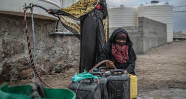 Zwei Frauen befüllen Wasserkanister