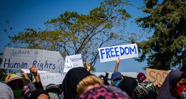 Protestierende Menschen halten Schilder hoch mit der Aufschrift "Freedom" und "Where is Human Rights?"