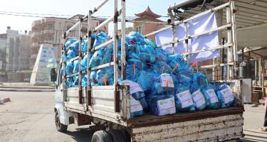 Im südlichen Gazastreifen verteilt Oxfams lokale Partnerorganisation Hygienesets Ein rostiger Lastwagen transportiert mit Hilfsgütern gefüllte blaue Plastiksäcke